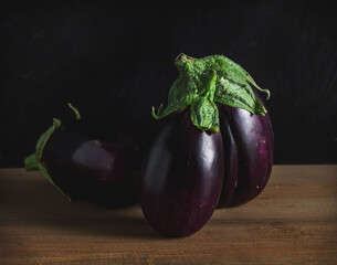 Three small eggplants on a wood table