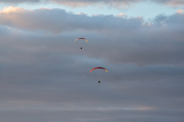 paragliders high in the sky above the ground