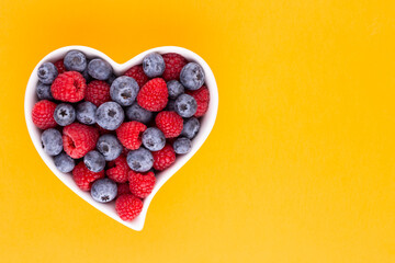 Creative layout made of Blueberry and raspberries on pastel background. Food ingredient pattern.