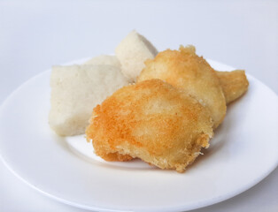 Jadah ketan, is a traditional snack from Indonesia. Made from sticky rice and grated coconut. Comparison before and after fried. On a white plate, isolated in white background