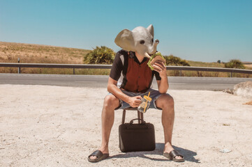 Imagen conceptual de un hombre con cabeza o mascara de elefante haciendo un descanso en el trabajo...