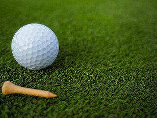 Tee with White golf ball on the green field