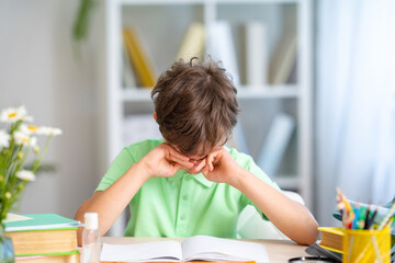 tired schoolboy cries, rubs his eyes, because he no longer wants to read