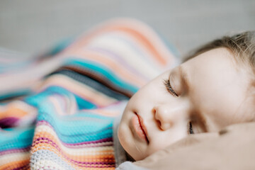 Young mother and baby of 2 years sleep together hugging, daytime sleep concept for children. Mom fell asleep with her baby while putting her to sleep