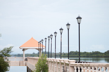 Many vintage style lamps Decorate the exterior of the building Riverside promenade On a beautiful sky day. The image is only partially clear.