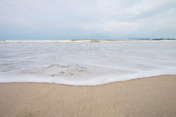 Water waves breaking on the sandy beach On days when the sea and sky are bright and beautiful and that there are no people