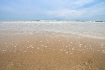 Water waves breaking on the sandy beach On days when the sea and sky are bright and beautiful and that there are no people