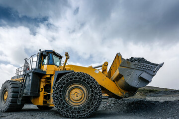 Obraz na płótnie Canvas Wheel loader with ore in the bucket at the gold mining site.