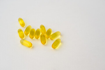 some fish oil yellow transparent capsules on white background with copy space
