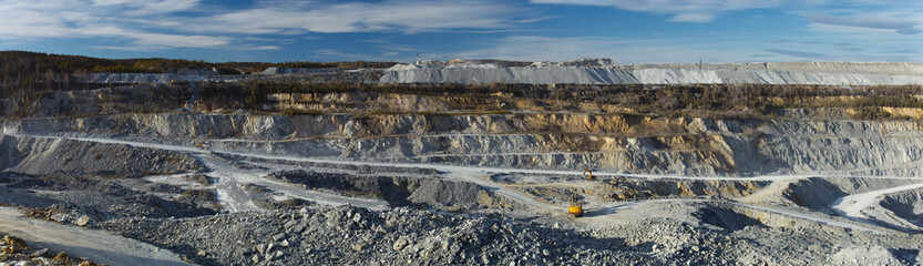 Panorama of the relief in a large stone quarry for the extraction of limestone with working in it...