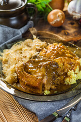 Fried ribs in sauerkraut served with boiled potatoes.