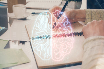 Fototapeta premium Double exposure of writing hand on background with brain hologram. Concept of learning.