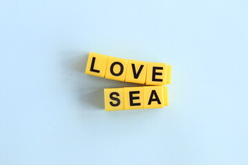 love sea concept, lettering in yellow letters on a blue background