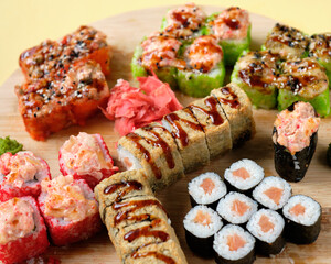 Fresh assorted Japanese sushi rolls with pickled ginger and wasabi on the wooden board. Restaurant or cafe menu images. Food photography. Top view.