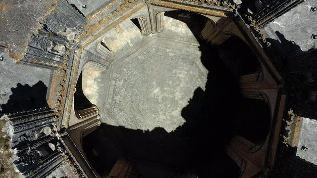 Aerial top view of Unfinished chapels at Batalha Monastery, Leiria, Portugal. Dominican convent with Manueline style architecture. Upward camera movement.