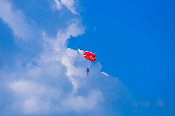 Fototapeta na wymiar Skydiver and colorful parachute on the blue sky 