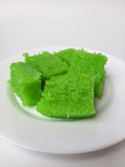 Wajik ketan, is a traditional snack from Indonesia. Made from sticky rice. On a white plate, isolated in white background.