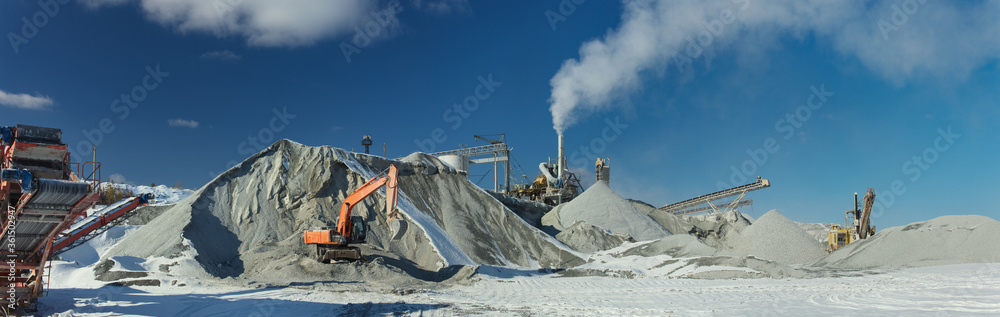 Wall mural excavators and stone crushing equipment of mining and processing plant on the background of a blue s