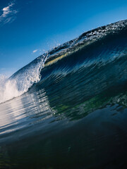Blue glassy wave and sky. Crashing ocean wave