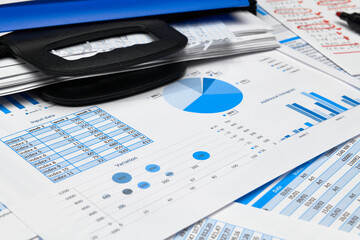 business office desk closeup - financial reports, analysis and accounting, set of documents, tables and graphs, various items for bookkeeping, calculator