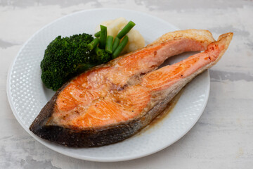 fried salmon trout with boiled vegetables on the dish