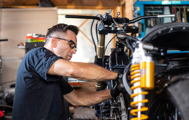 Fototapeta na wymiar mechanic working on the repair of a motorcycle in the workshop
