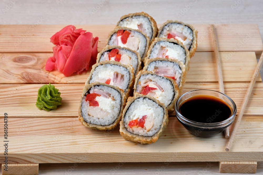 Wall mural japanese sushi rolls with fish avocado, cheese, wasabi, soy sauce, and marinated ginger. tasty and a