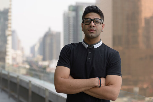 Young handsome Indian man with eyeglasses in the city