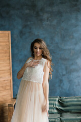 Fototapeta premium Morning of the bride. Sexy girl posing in white lace underwear. Portrait of a beautiful young female in a white underwear. Seductive woman in white linen and a peignoir.