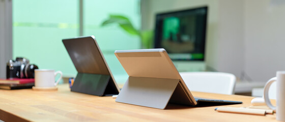 Portable workspace with digital tablets and office supplies on wooden worktable