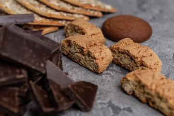 Cookies and dark chocolate on concrete textured background.