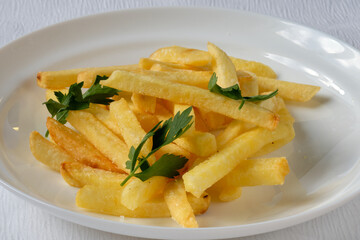 sliced fried potatoes with parsley on a white plate. Download full menu in my catalog. Food photography. 