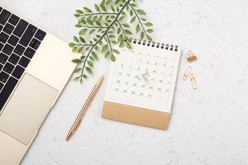 Calendar with gold pen and green leaf