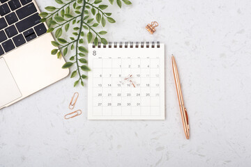 Calendar with rose gold pen on white quartz table