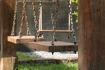 Wooden plank flooring Empty, without people and used for sitting on a swing and fastened with a large iron chain