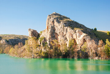 Beautiful view of turquoise water lake and big rock in Spain. Nature card.