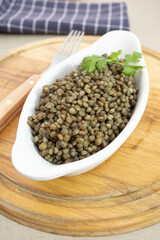 plat de lentilles cuites sur une planche à découper