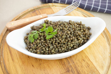 plat de lentilles cuites sur une planche à découper