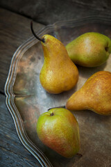 Pears on a tray and an old wooden background.
