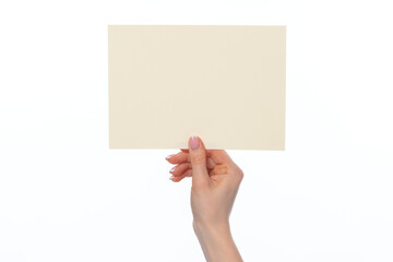 Obraz premium Female hand holding blank white sheet of paper isolated on white