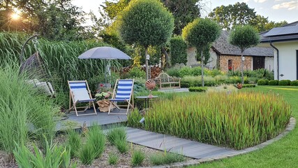 Letni ogród pełen traw, tarasdrewniany w pięknym ogrodzie, parasol przeciwsłoneczny i leżaki w ogrodzie - obrazy, fototapety, plakaty