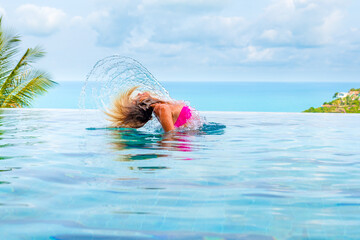 beautiful woman in a pool in a bikini and enjoys a tropical paradise on Koh Samui in Thailand,...