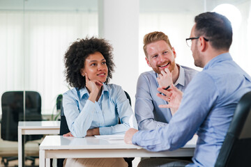 Positive business people on a meeting with manager in the office.