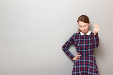 Portrait of serious discerning girl making money gesture with fingers