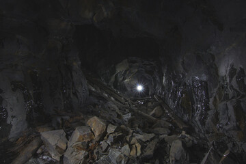 Extensive stone hall in an abandoned mine with traces of collapsed rocks. Spelestology.