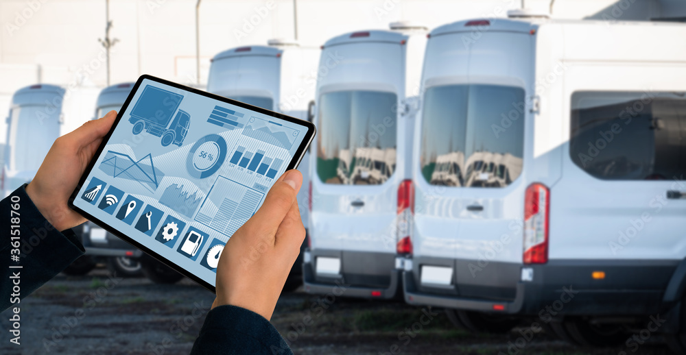 Poster manager with a digital tablet on the background of trucks. fleet management