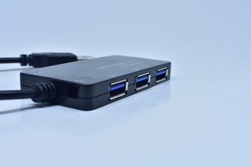 Closeup of a black portable USB hub with a wire isolated on white background