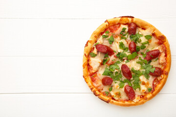 Tasty Italian pizza with sausage on white wooden table with copy space
