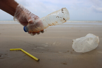 Beach clean up. Picking up plastic straws, bottles and bags which pollute the sea shore