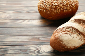 Fresh baked bread on brown wooden background with copy space.